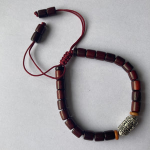 Pulsera con cuentas de madera barnizada y dije cilíndrico de Molino de Oración
