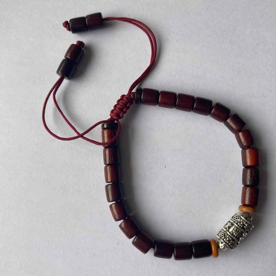 Pulsera con cuentas de madera barnizada y dije cilíndrico de Molino de Oración