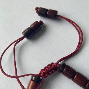 Pulsera con cuentas de madera barnizada y dije cilíndrico de Molino de Oración