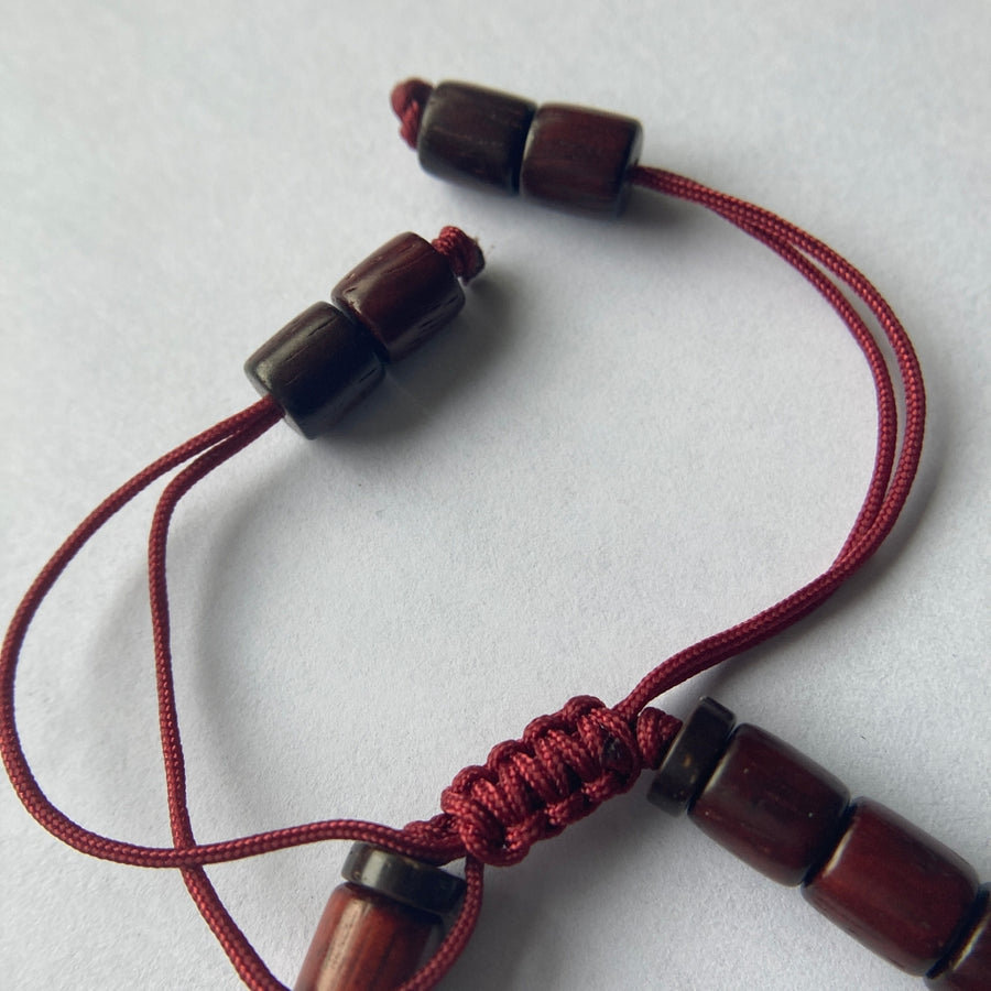 Pulsera con cuentas de madera barnizada y dije cilíndrico de Molino de Oración