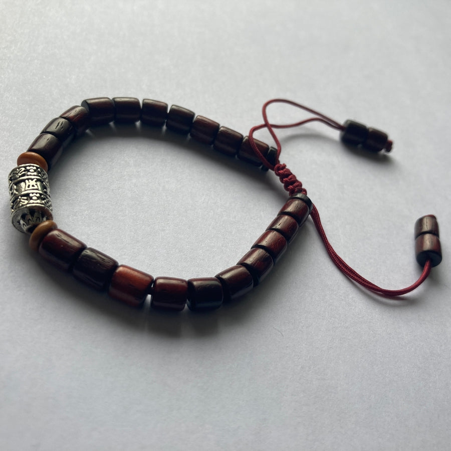 Pulsera con cuentas de madera barnizada y dije cilíndrico de Molino de Oración